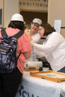 Faces are in awe as they learn from the Society of Women Engineering